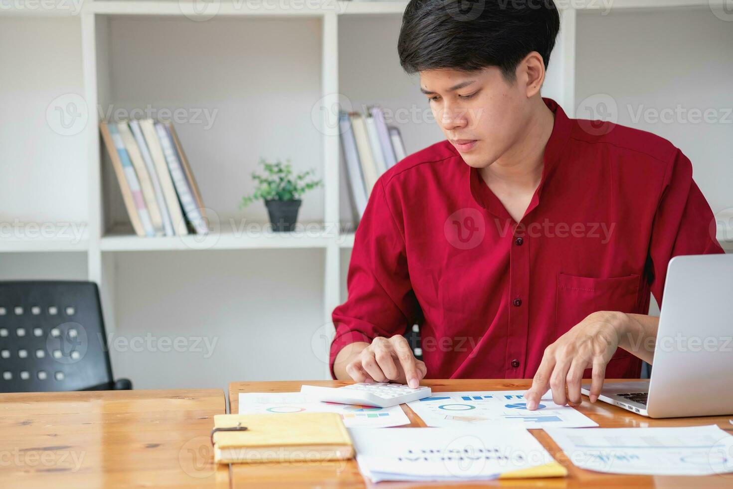 Business accounting concept, A businessman using a calculator with a computer laptop, budget, and loan paper in the office. photo