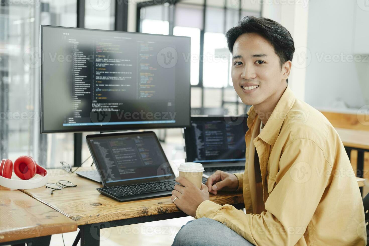 Young programmer working on desktop PC in office of software company. photo