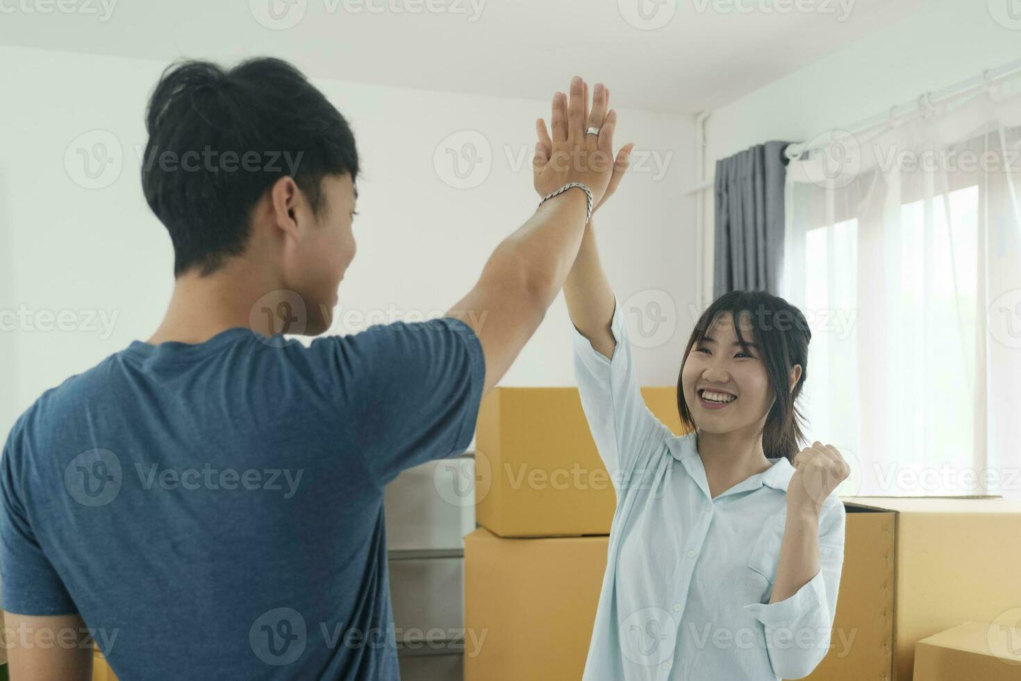 Happy couple with cardboard boxes in new house at moving day. photo