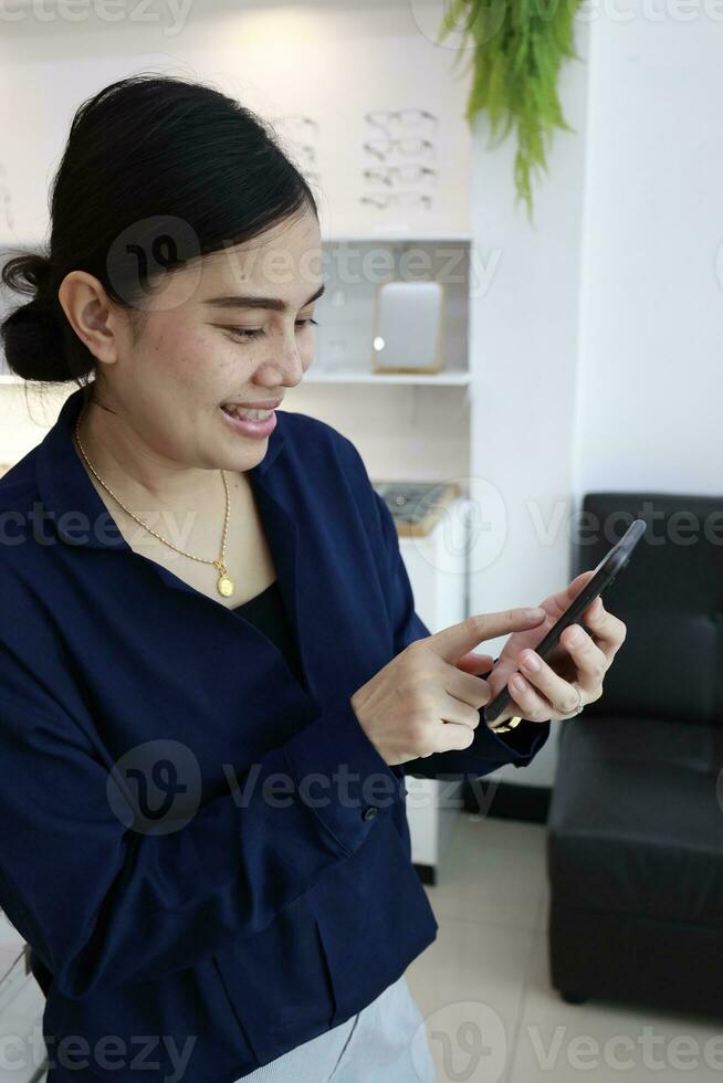Person using phone, woman using mobile phone at home photo