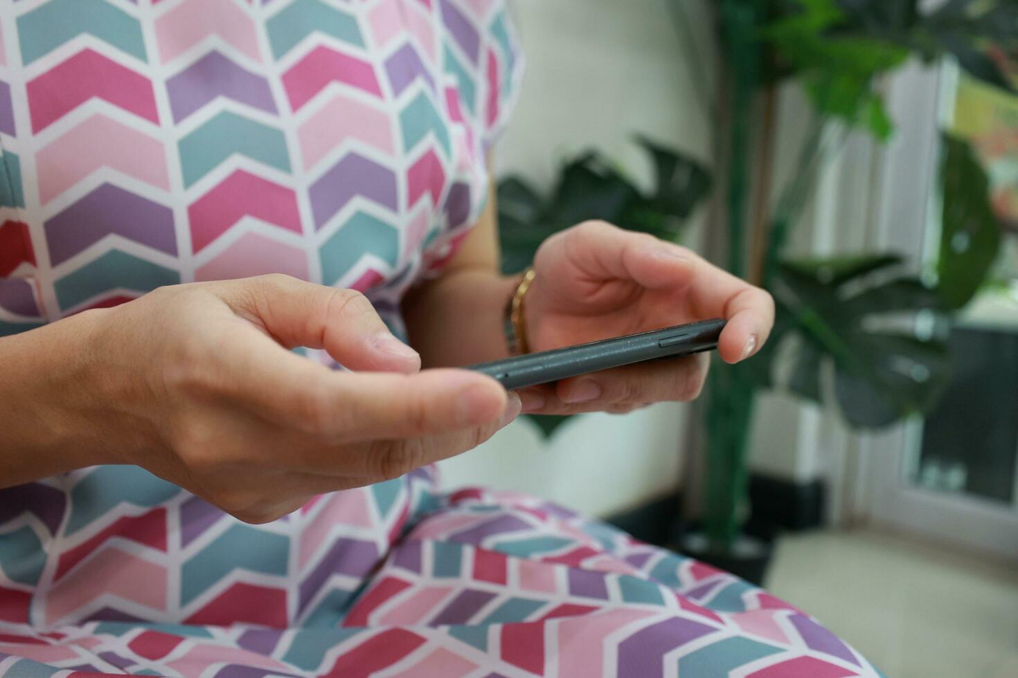Mobile phone in hand, hand using mobile phone in home photo