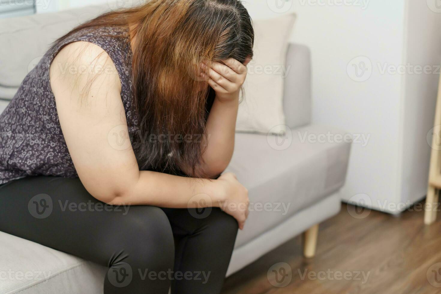 Sad Overweight plus size woman thinking about problems on sofa upset girl feeling lonely and sad from bad relationship or Depressed woman disorder mental health photo