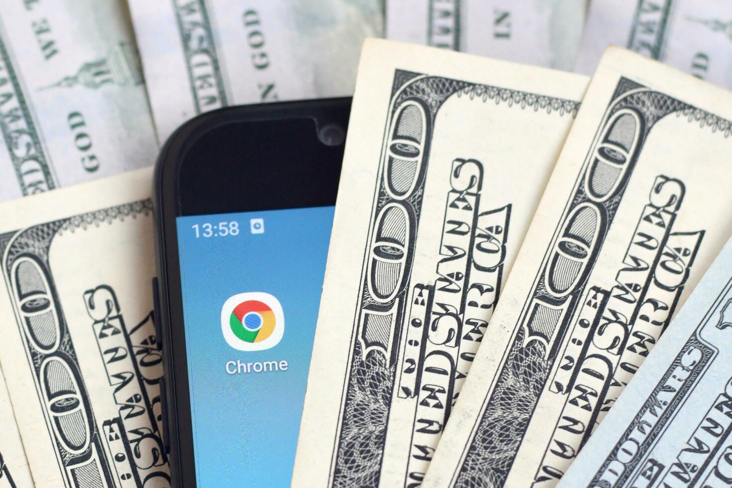 Smartphone screen with Google chrome app and lot of hundred dollar bills. Business and social networking concept photo