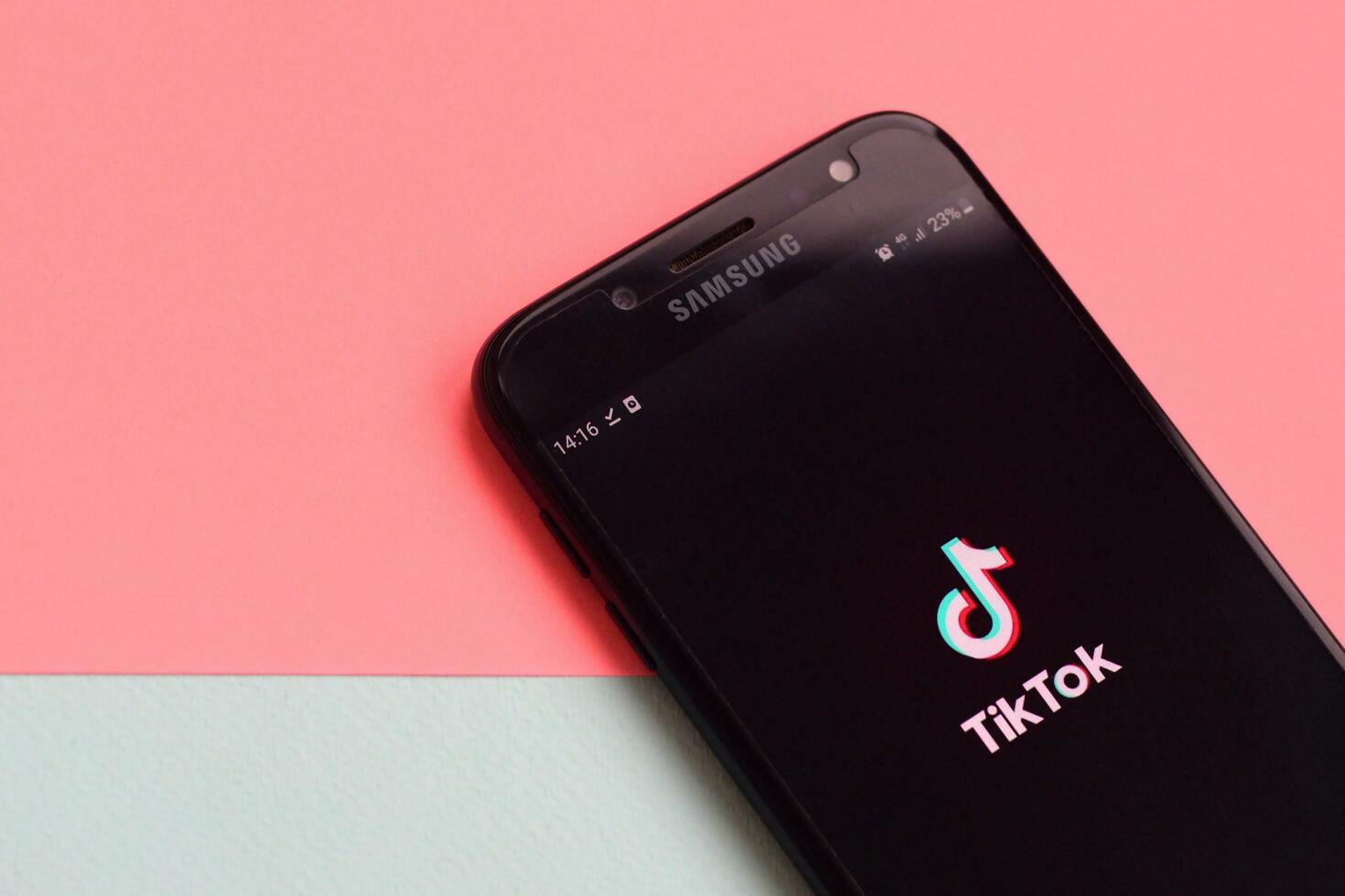 Tiktok application on samsung smartphone screen on pastel background. TikTok is a popular video-sharing social networking service owned by ByteDance photo