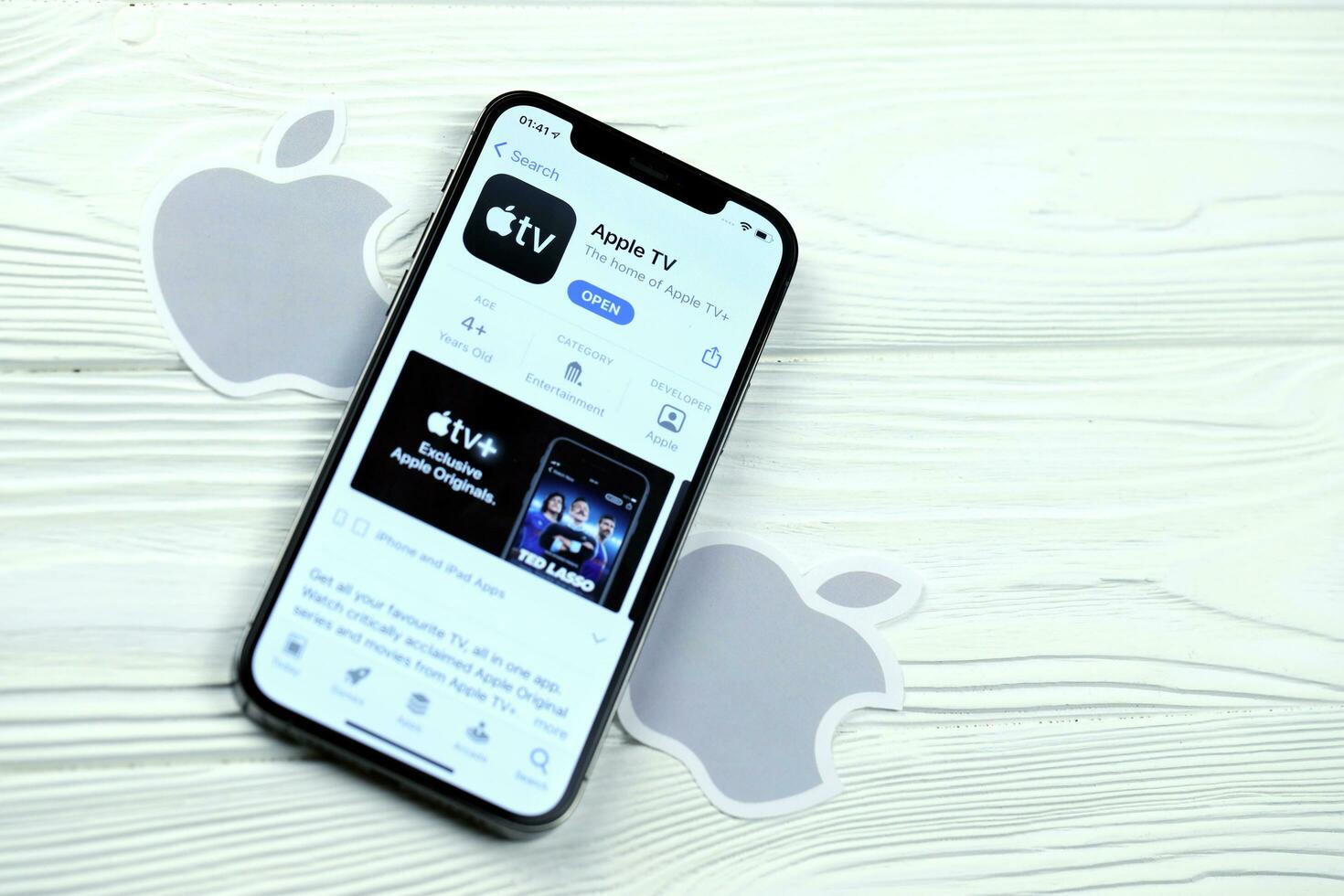KHARKOV, UKRAINE - MARCH 5, 2021 Apple TV icon and application from App store on iPhone 12 pro display screen on white table photo