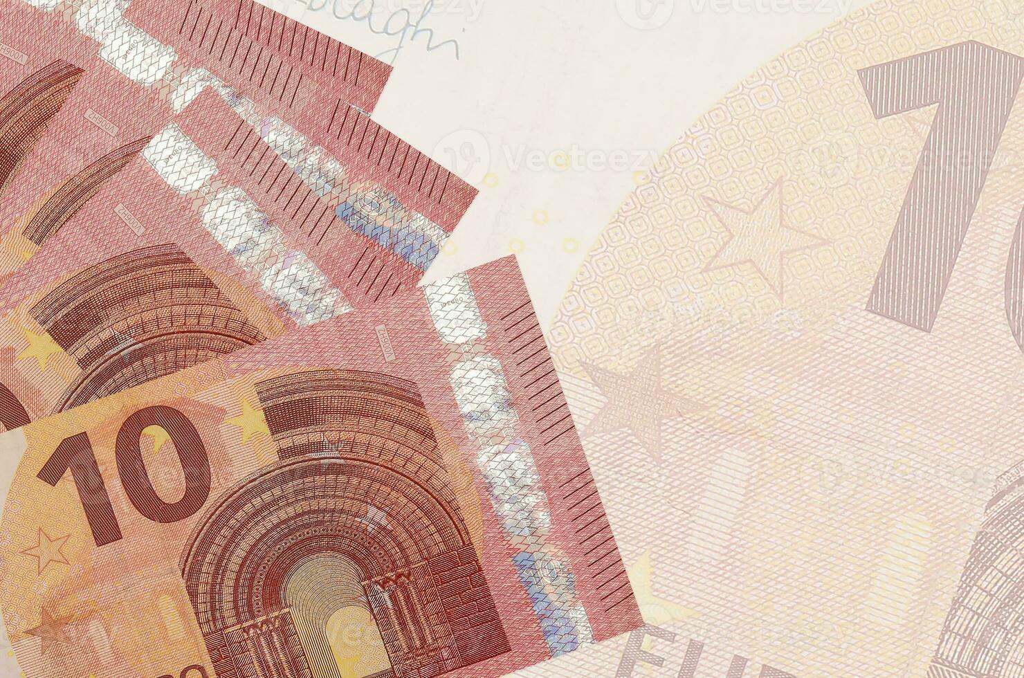 10 euro bills lies in stack on background of big semi-transparent banknote. Abstract business background photo