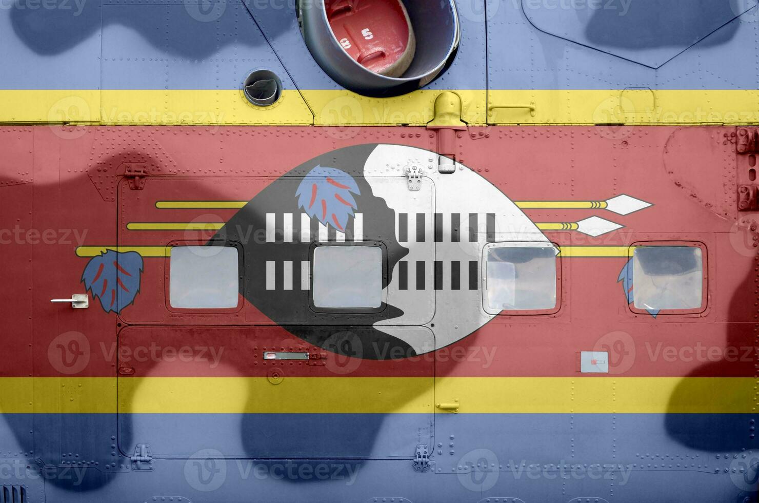 Swaziland flag depicted on side part of military armored helicopter closeup. Army forces aircraft conceptual background photo