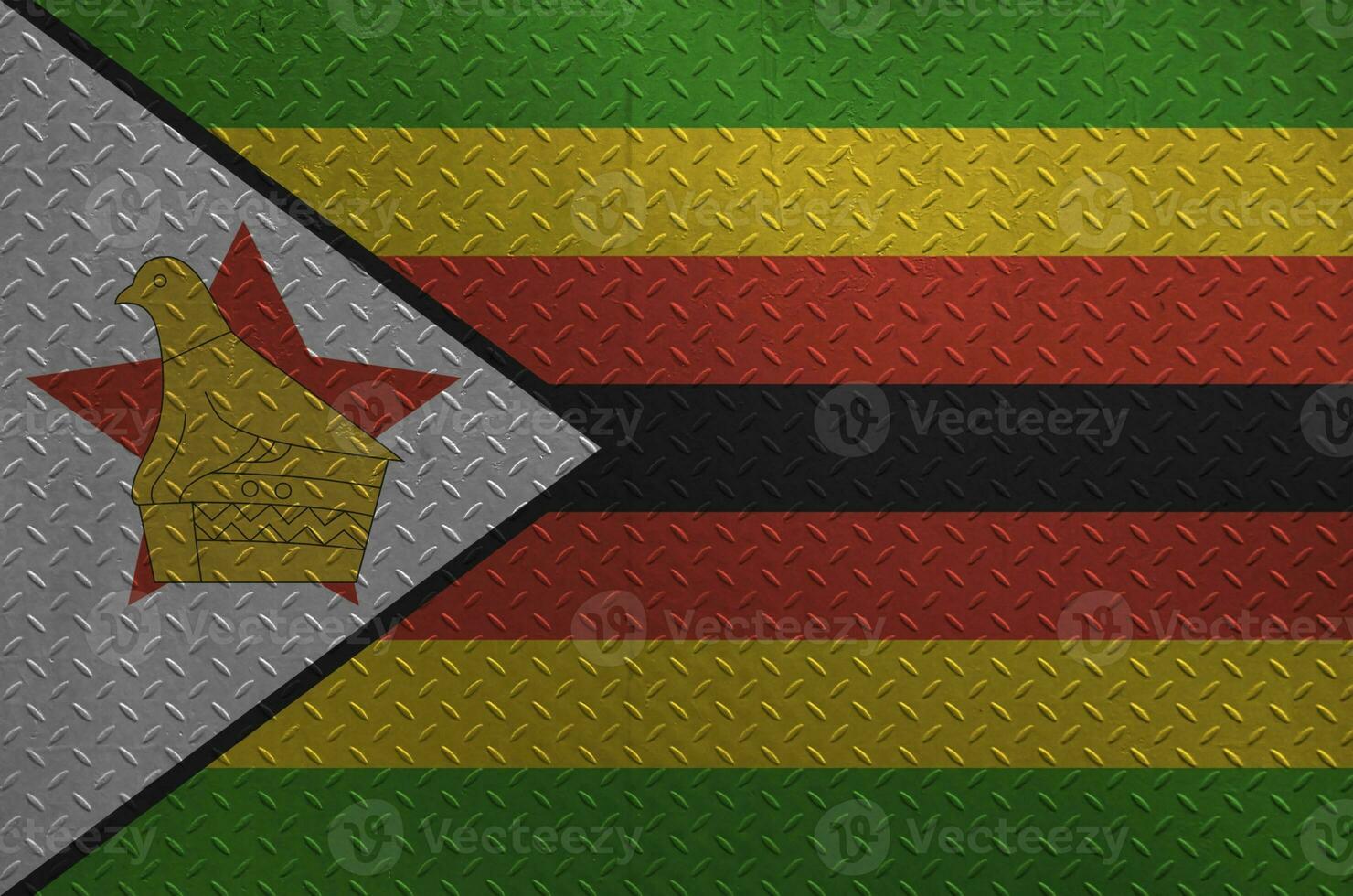 Zimbabwe flag depicted in paint colors on old brushed metal plate or wall closeup. Textured banner on rough background photo