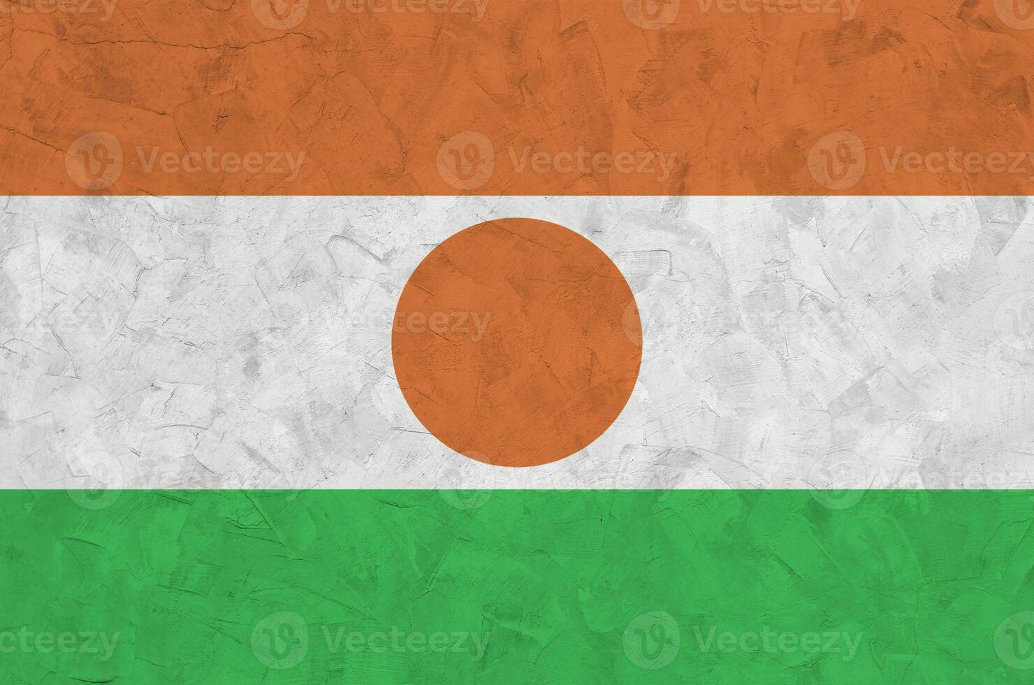 Niger flag depicted in bright paint colors on old relief plastering wall. Textured banner on rough background photo