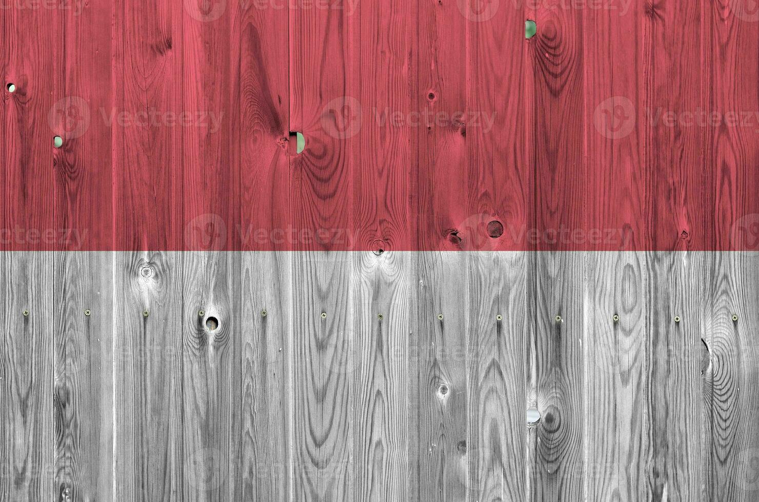 Monaco flag depicted in bright paint colors on old wooden wall. Textured banner on rough background photo