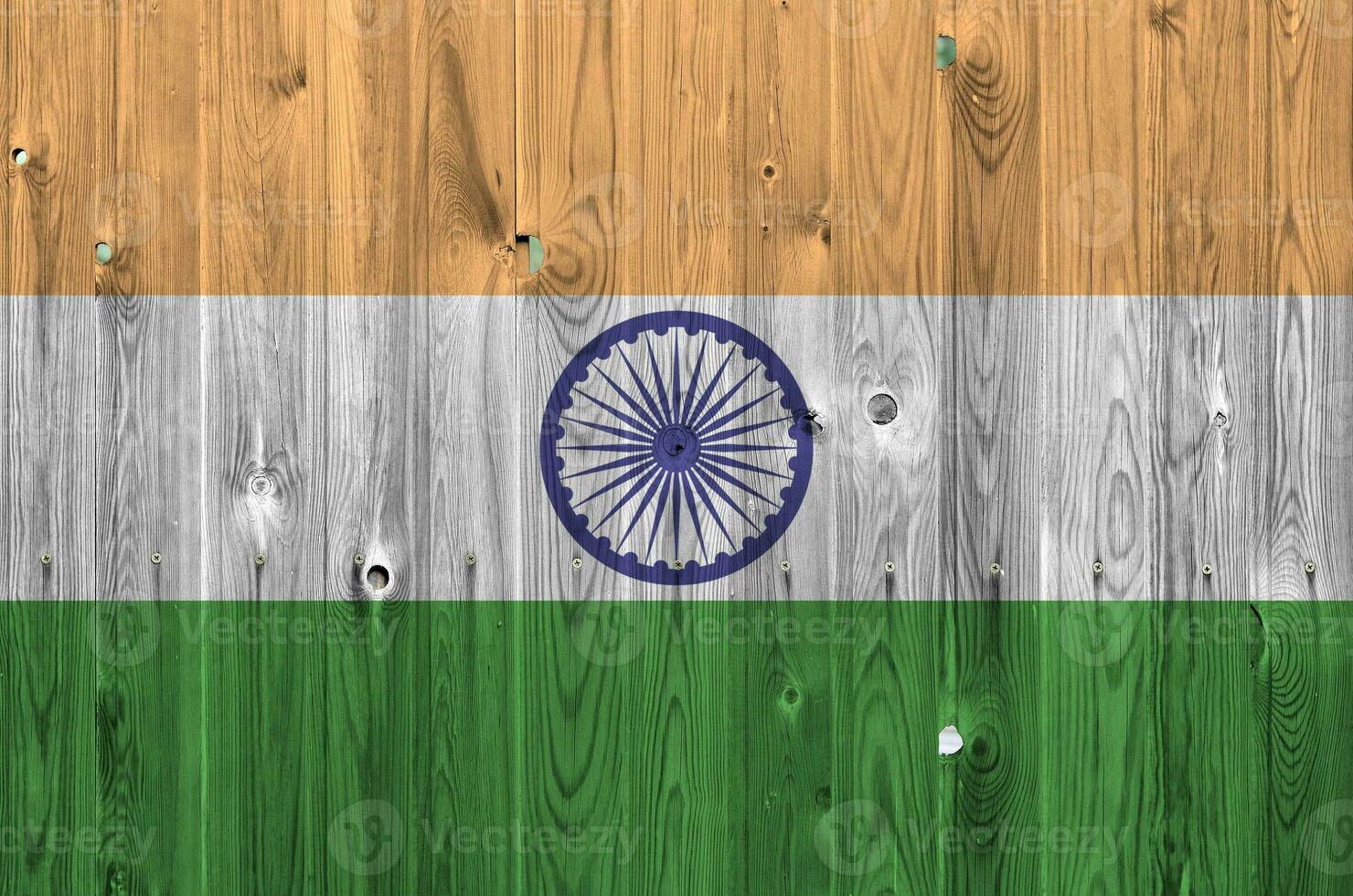 India flag depicted in bright paint colors on old wooden wall. Textured banner on rough background photo