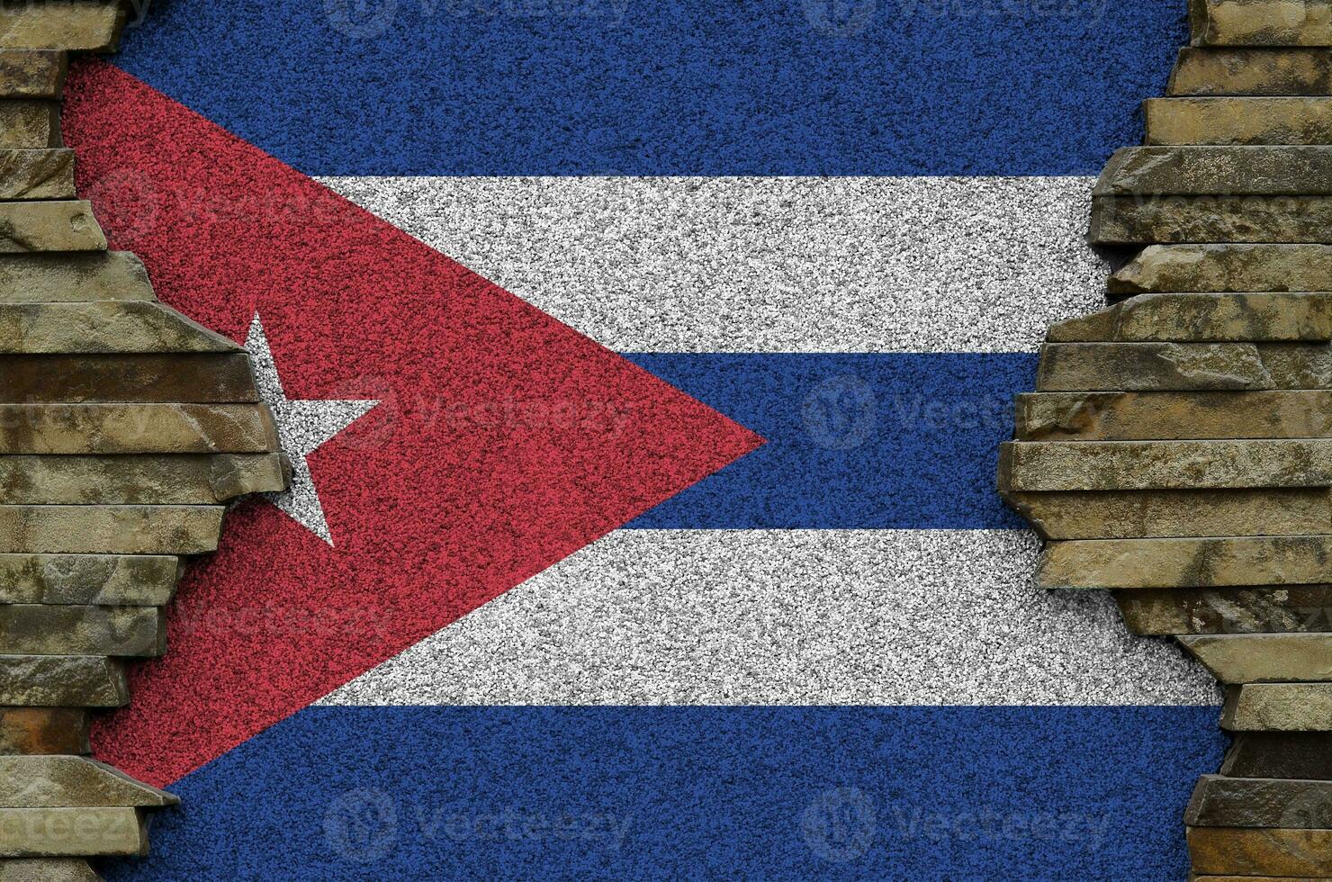 Cuba flag depicted in paint colors on old stone wall closeup. Textured banner on rock wall background photo