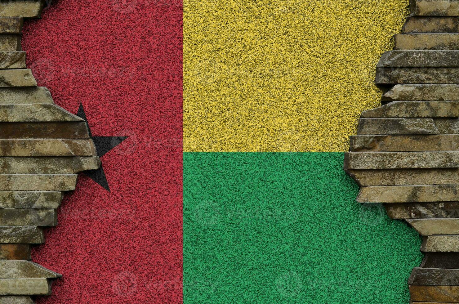 Guinea Bissau flag depicted in paint colors on old stone wall closeup. Textured banner on rock wall background photo