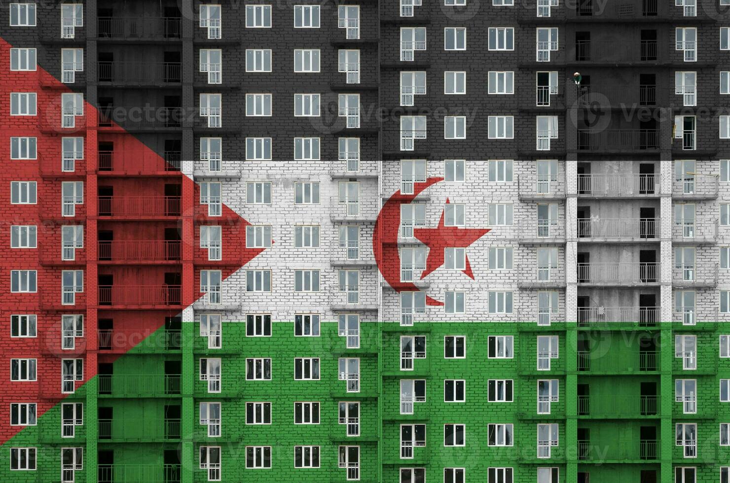 Western Sahara flag depicted in paint colors on multi-storey residental building under construction. Textured banner on brick wall background photo