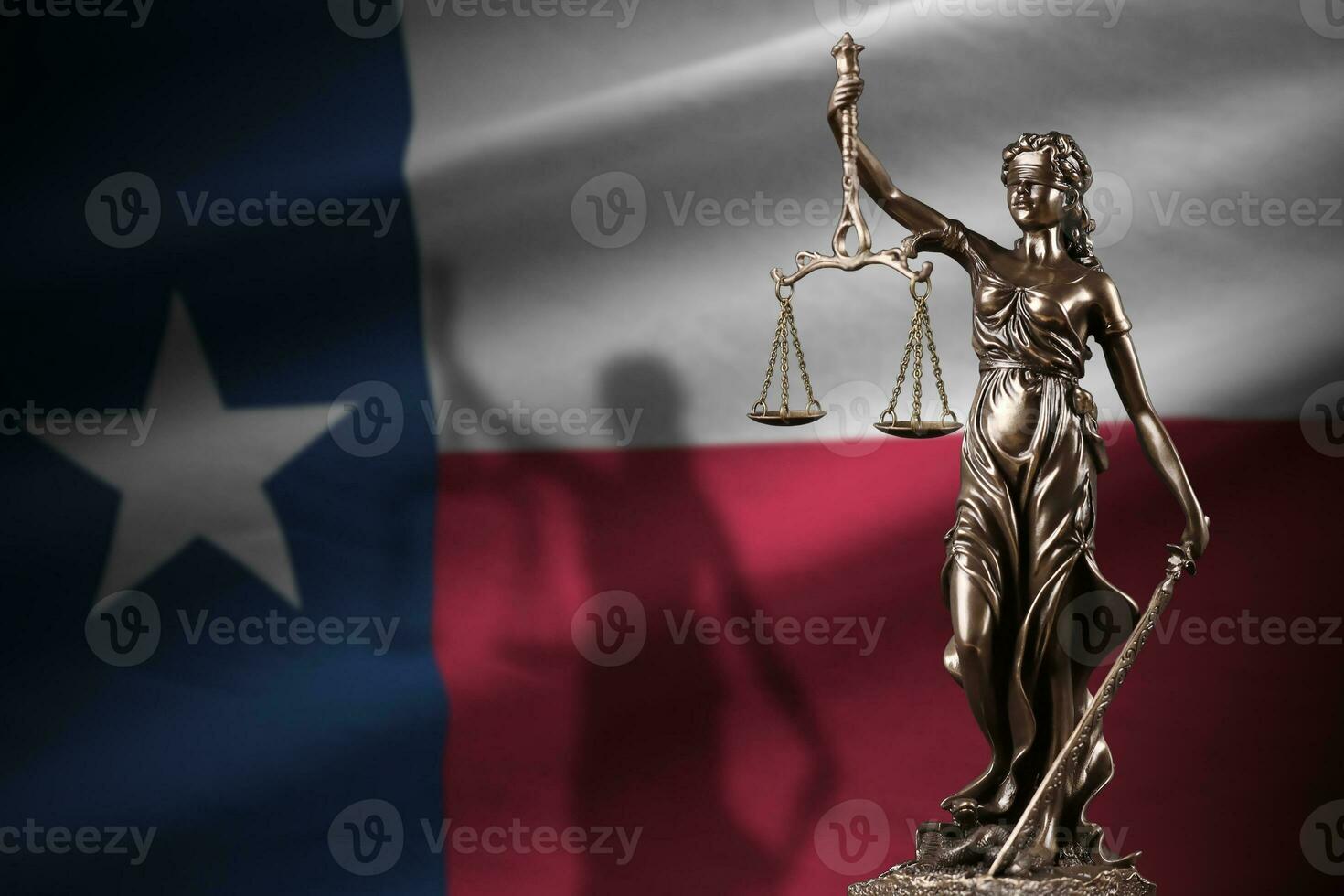 Texas US state flag with statue of lady justice and judicial scales in dark room. Concept of judgement and punishment photo