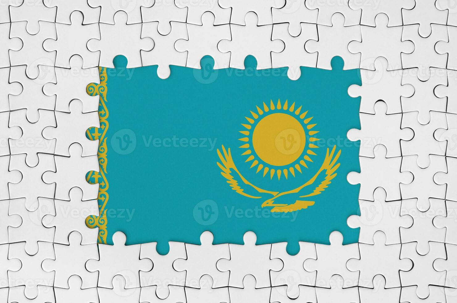 Kazakhstan flag in frame of white puzzle pieces with missing central part photo