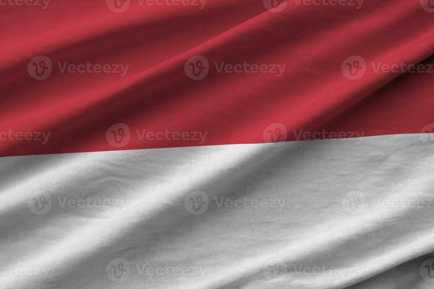bandera de indonesia con grandes pliegues ondeando de cerca bajo la luz del estudio en el interior. los símbolos y colores oficiales en banner foto