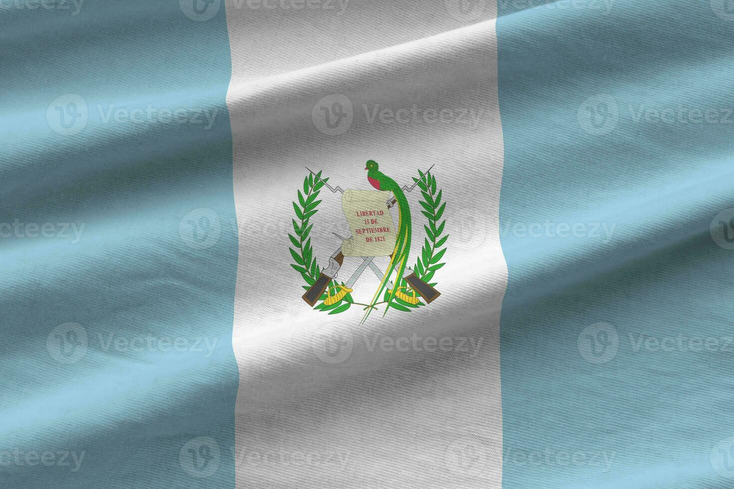 bandera de guatemala con grandes pliegues ondeando de cerca bajo la luz del estudio en el interior. los símbolos y colores oficiales en banner foto