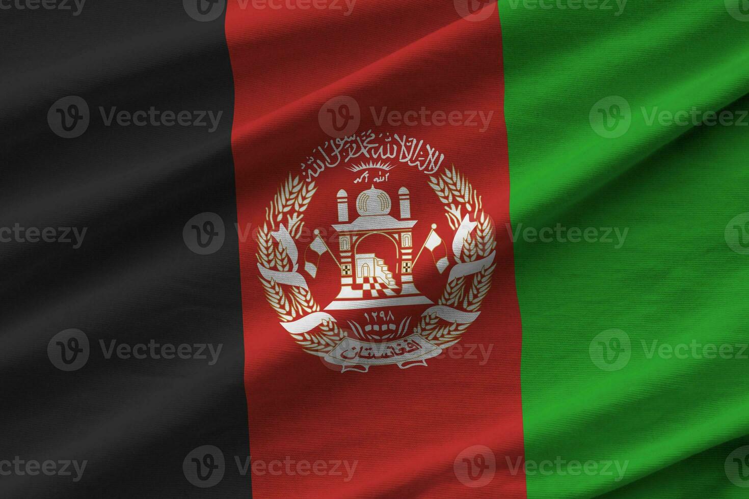 Afghanistan flag with big folds waving close up under the studio light indoors. The official symbols and colors in banner photo