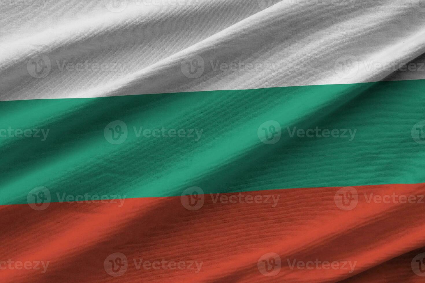 bandera de bulgaria con grandes pliegues ondeando de cerca bajo la luz del estudio en el interior. los símbolos y colores oficiales en banner foto