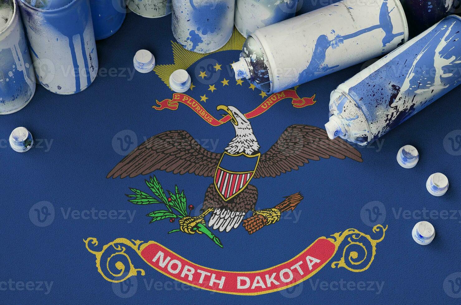 North Dakota US state flag and few used aerosol spray cans for graffiti painting. Street art culture concept photo