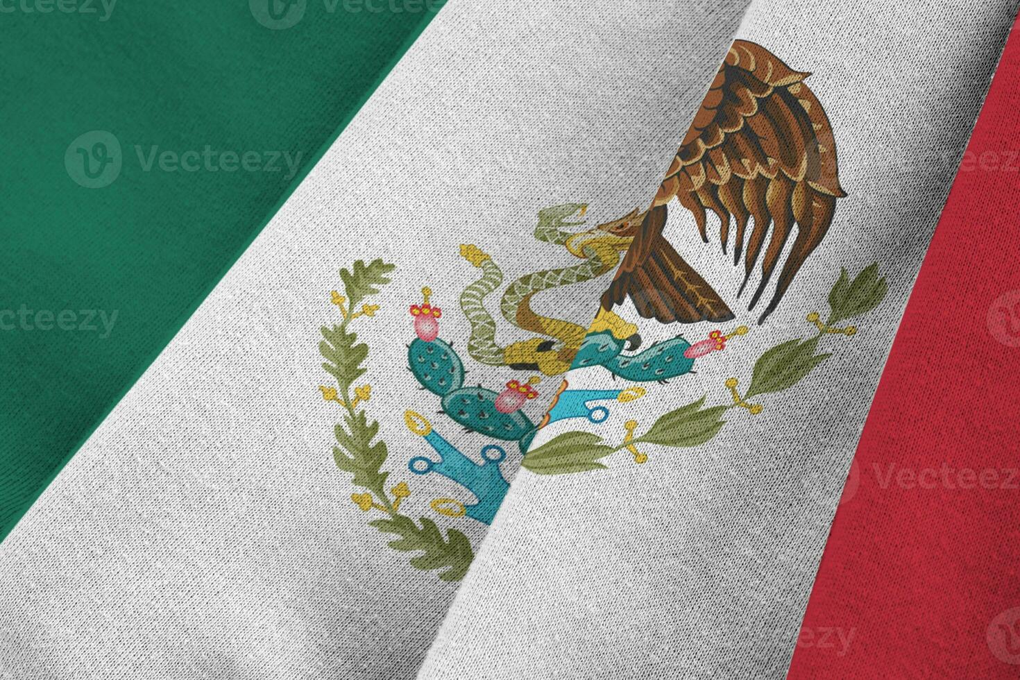 bandera de méxico con grandes pliegues ondeando de cerca bajo la luz del estudio en el interior. los símbolos y colores oficiales en banner foto