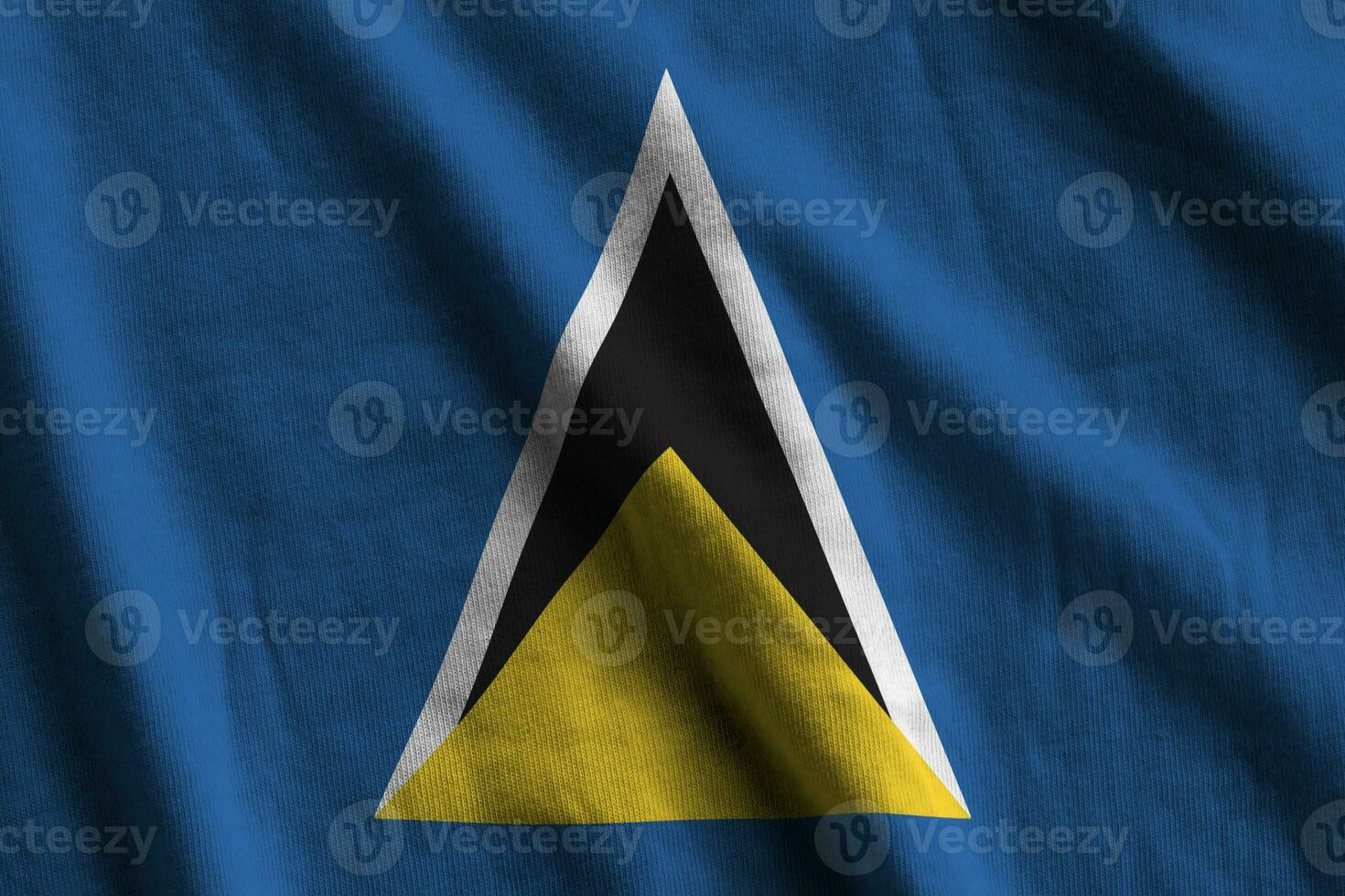 Saint Lucia flag with big folds waving close up under the studio light indoors. The official symbols and colors in banner photo