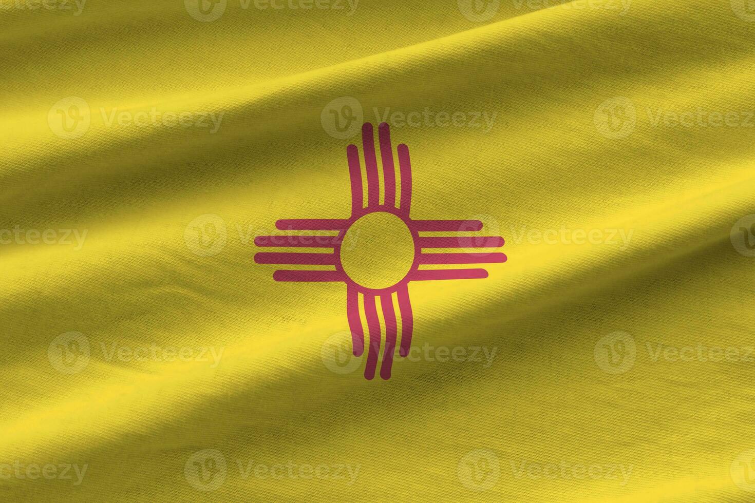 New Mexico US state flag with big folds waving close up under the studio light indoors. The official symbols and colors in banner photo