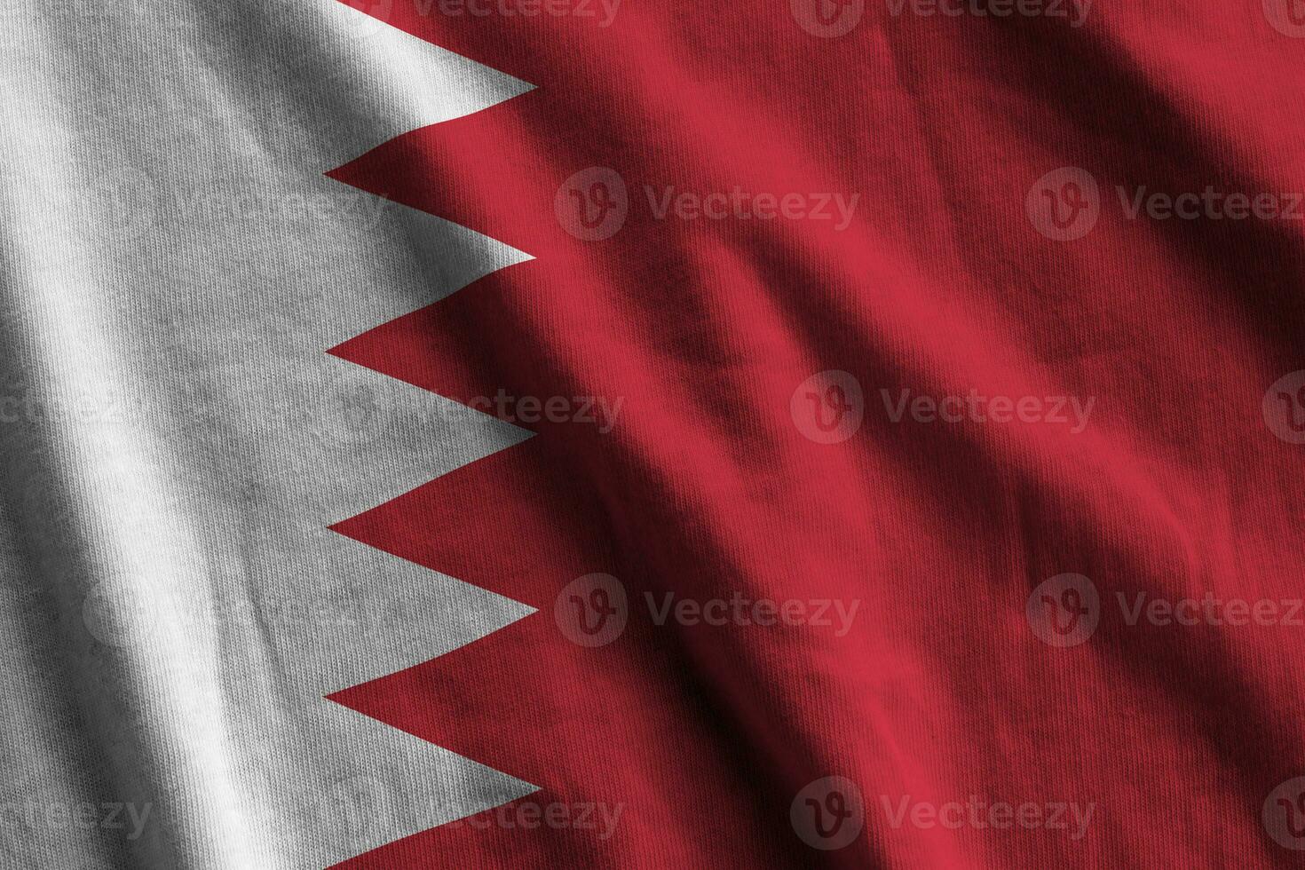 Bahrain flag with big folds waving close up under the studio light indoors. The official symbols and colors in banner photo