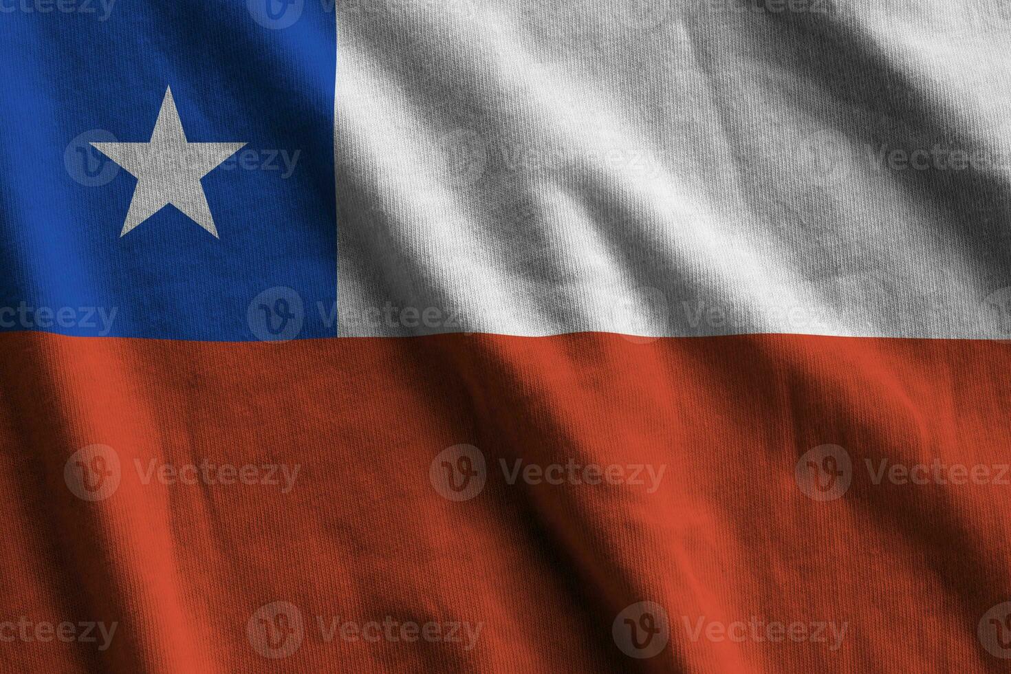 bandera chilena con grandes pliegues ondeando de cerca bajo la luz del estudio en el interior. los símbolos y colores oficiales en banner foto