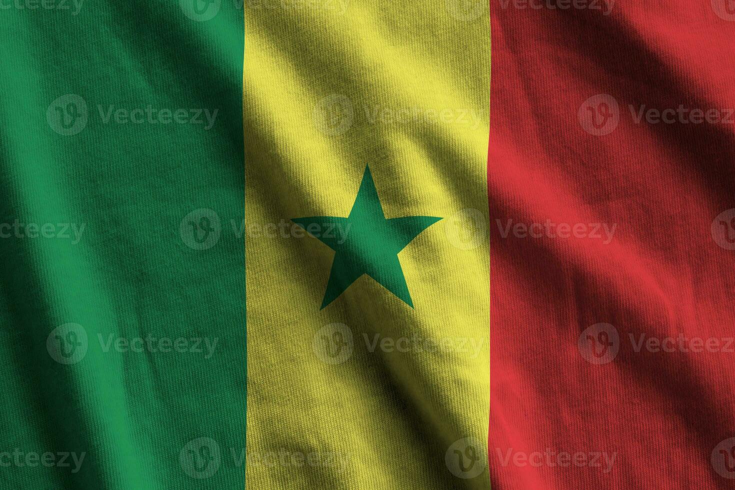 Senegal flag with big folds waving close up under the studio light indoors. The official symbols and colors in banner photo