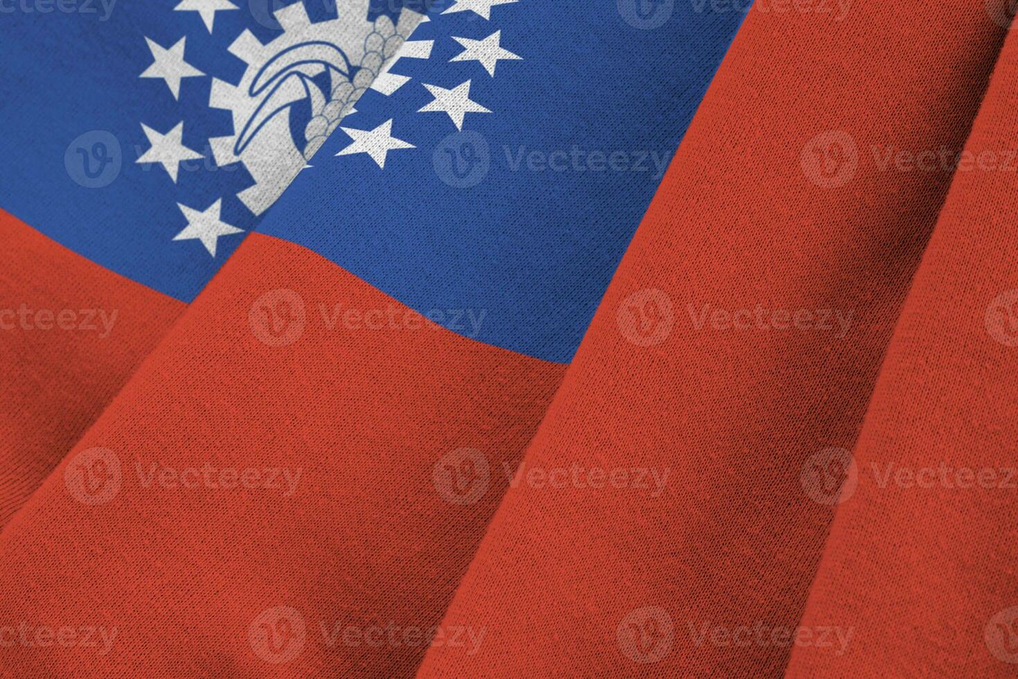 Myanmar flag with big folds waving close up under the studio light indoors. The official symbols and colors in banner photo