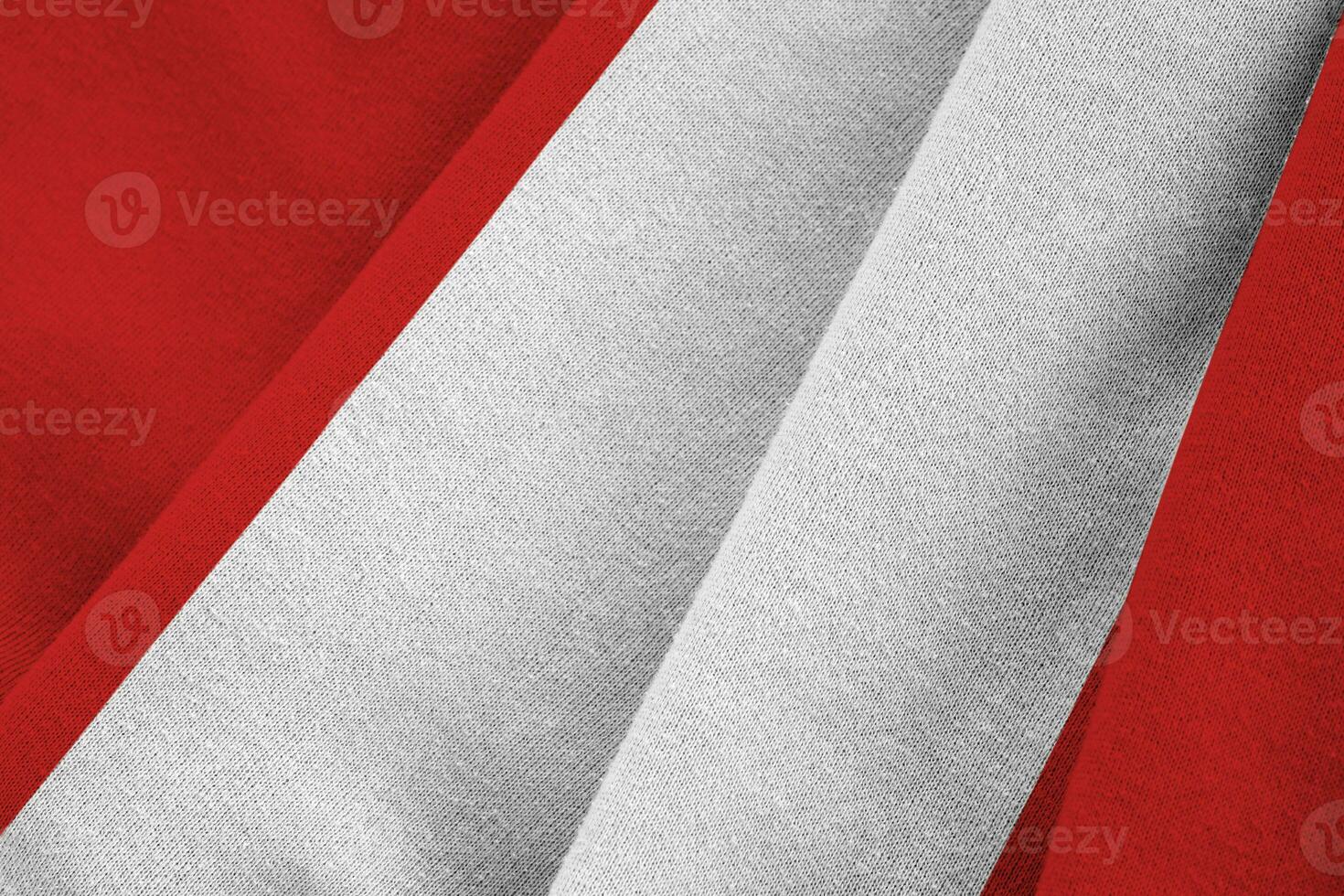 Peru flag with big folds waving close up under the studio light indoors. The official symbols and colors in banner photo