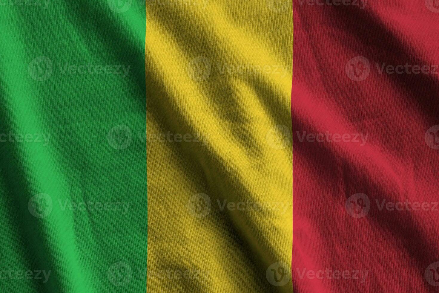 Mali flag with big folds waving close up under the studio light indoors. The official symbols and colors in banner photo