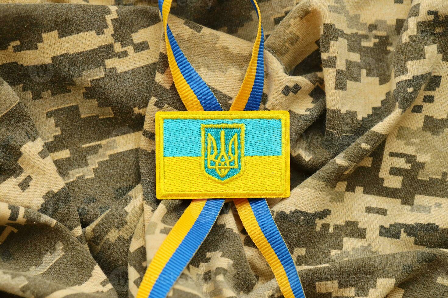 Military camouflage fabric with ukrainian flag on uniform chevron photo