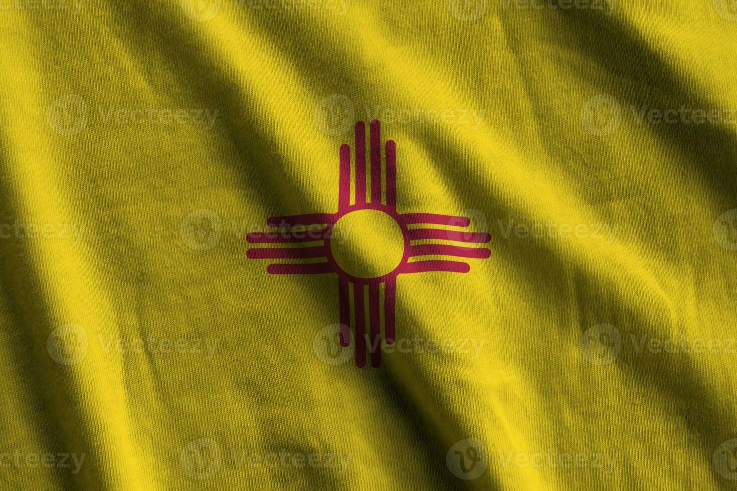 New Mexico US state flag with big folds waving close up under the studio light indoors. The official symbols and colors in banner photo