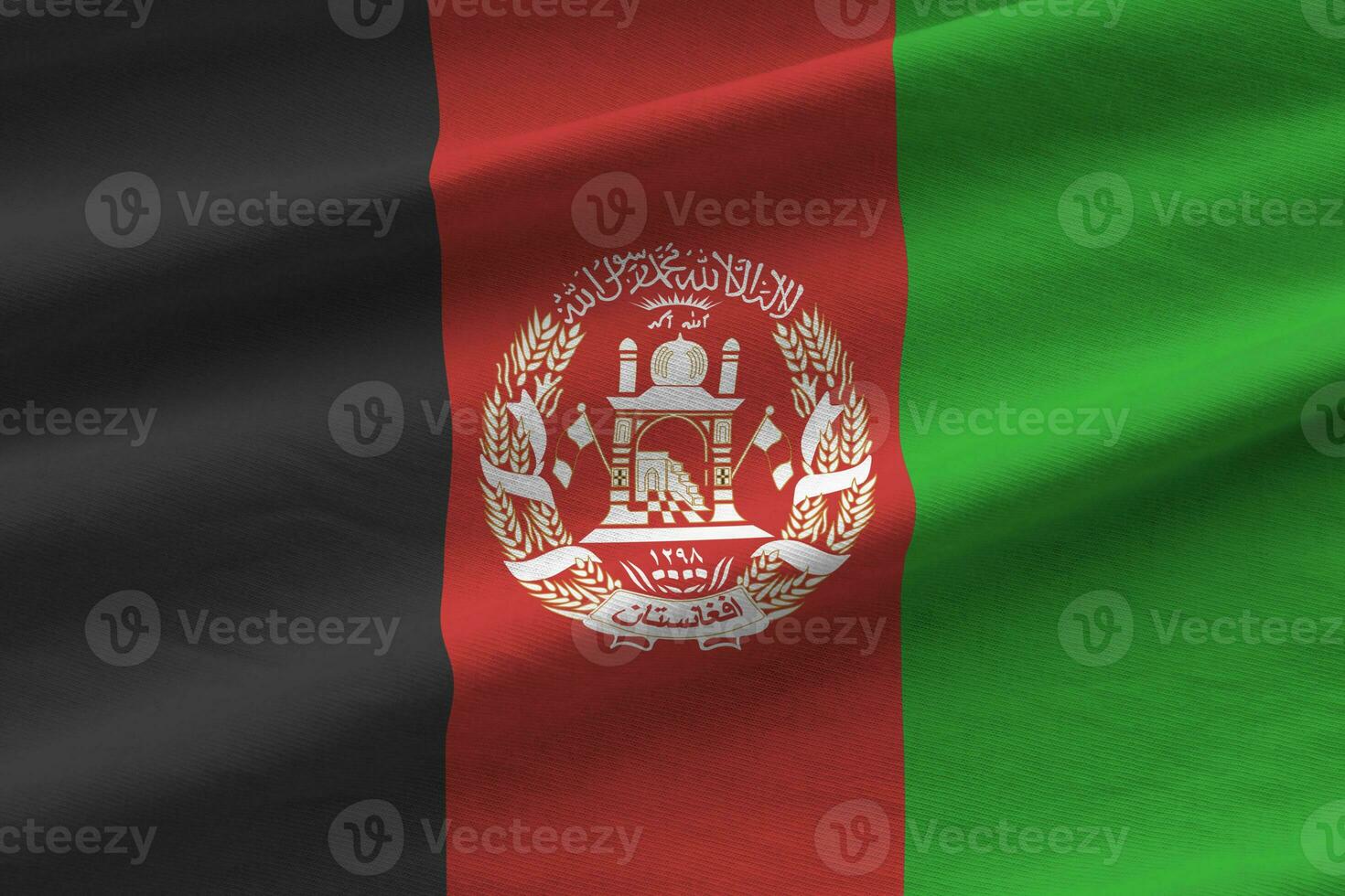 Afghanistan flag with big folds waving close up under the studio light indoors. The official symbols and colors in banner photo