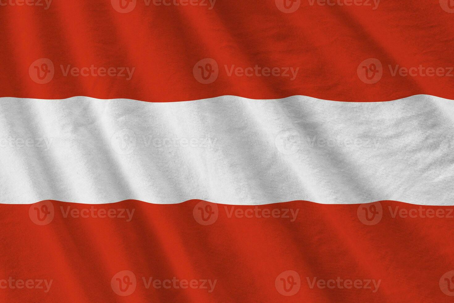 Austria flag with big folds waving close up under the studio light indoors. The official symbols and colors in banner photo