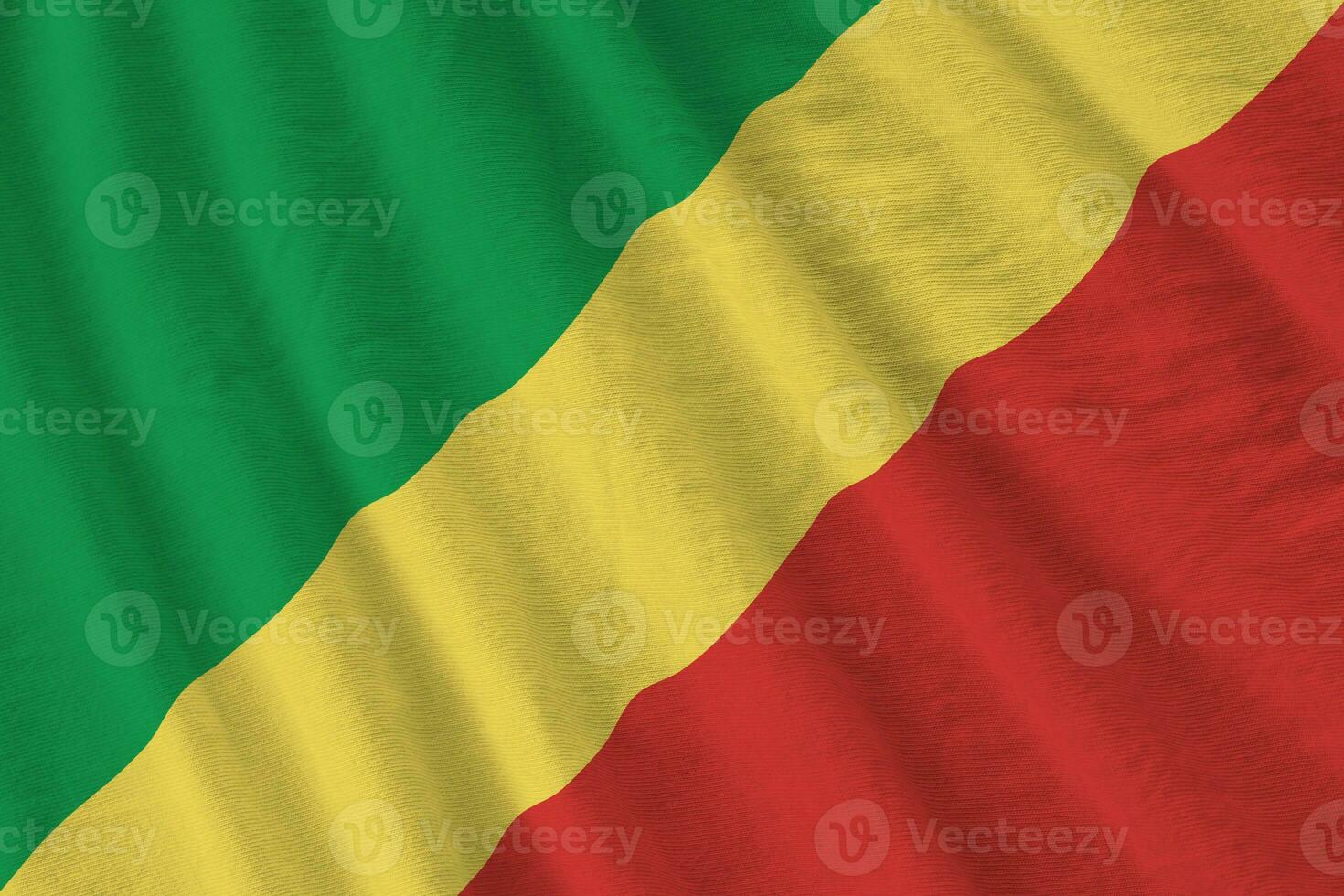 Congo flag with big folds waving close up under the studio light indoors. The official symbols and colors in banner photo