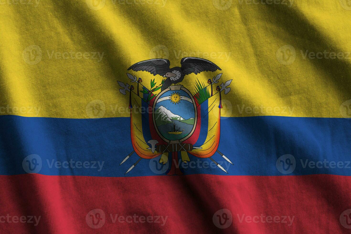 Ecuador flag with big folds waving close up under the studio light indoors. The official symbols and colors in banner photo