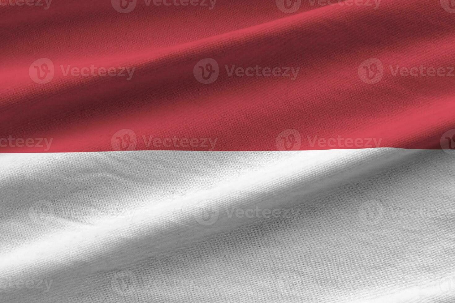 Indonesia flag with big folds waving close up under the studio light indoors. The official symbols and colors in banner photo