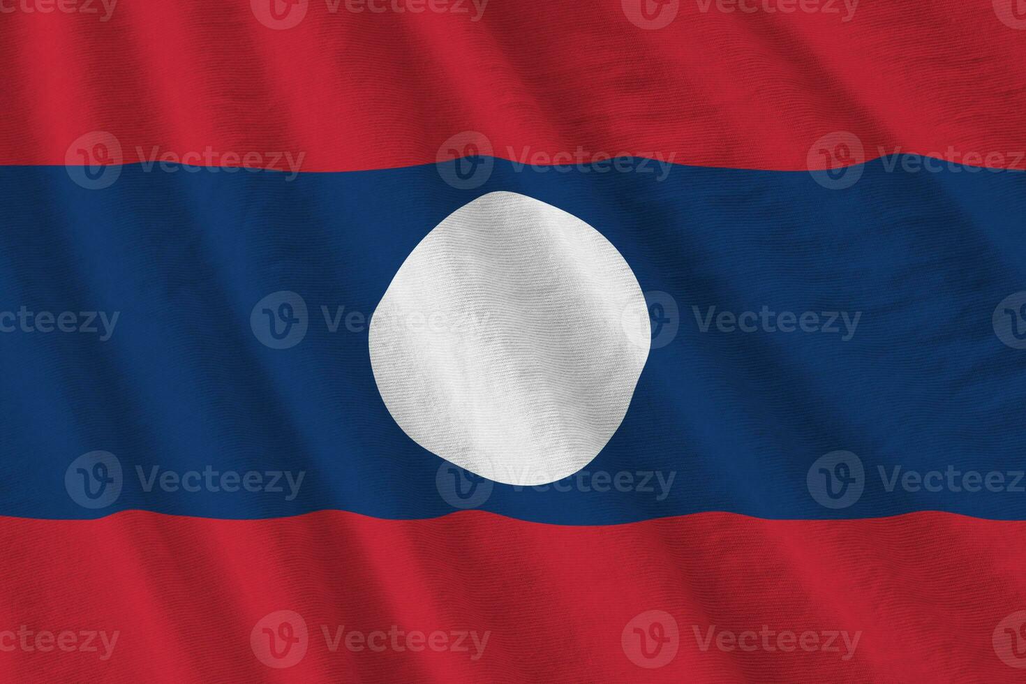 Laos flag with big folds waving close up under the studio light indoors. The official symbols and colors in banner photo