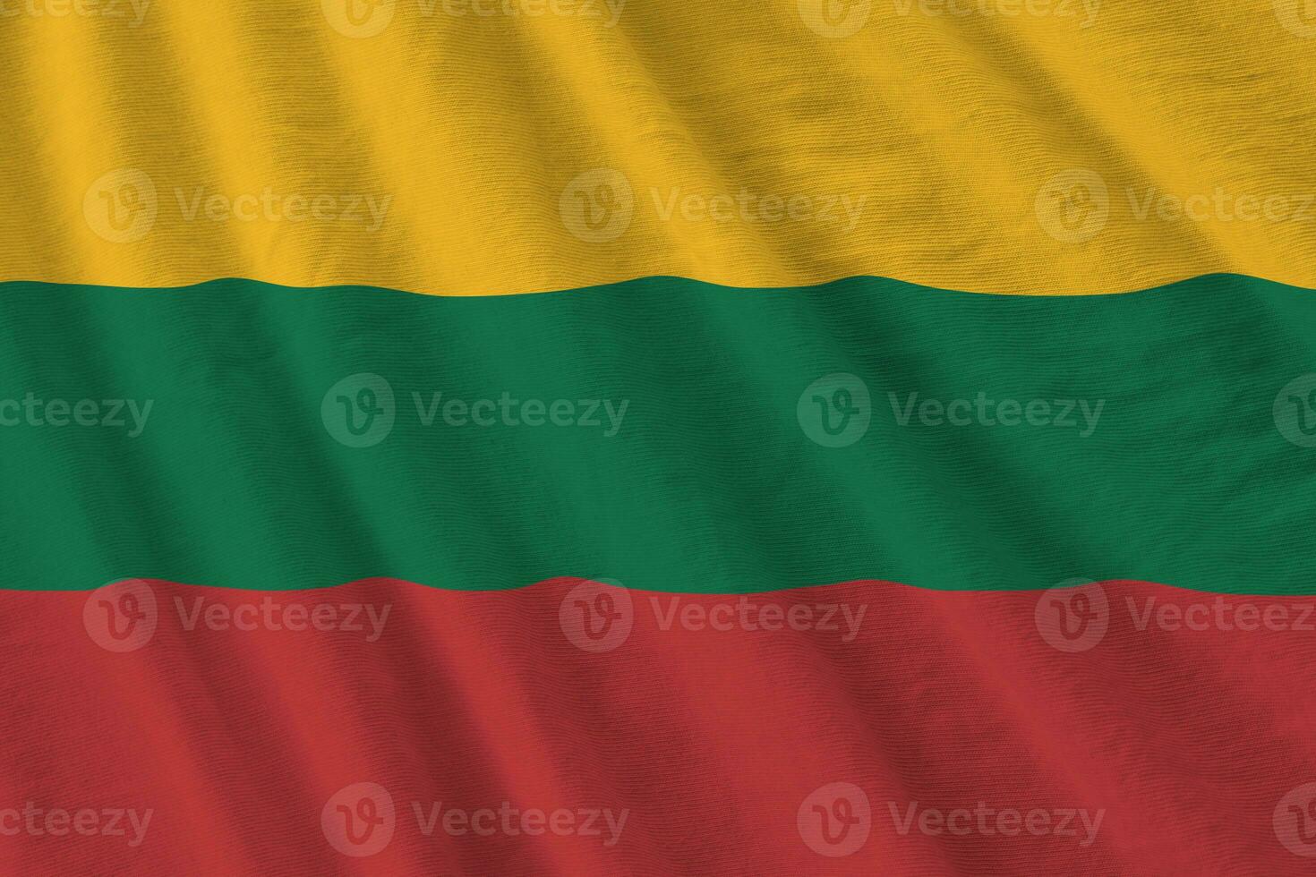 Lithuania flag with big folds waving close up under the studio light indoors. The official symbols and colors in banner photo