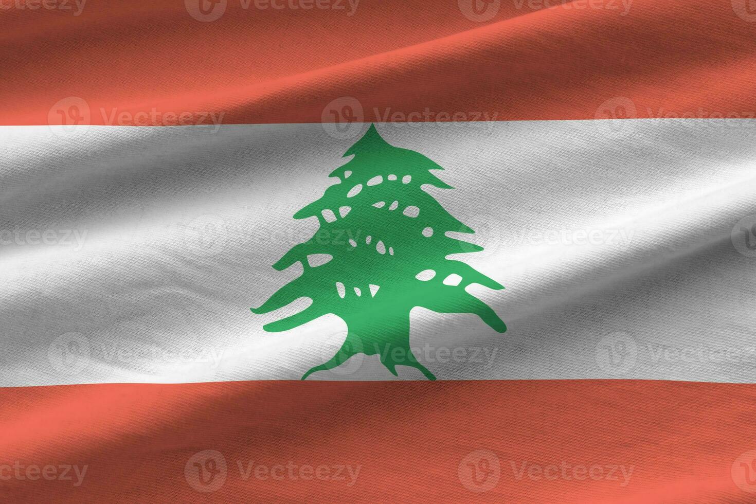 Lebanon flag with big folds waving close up under the studio light indoors. The official symbols and colors in banner photo