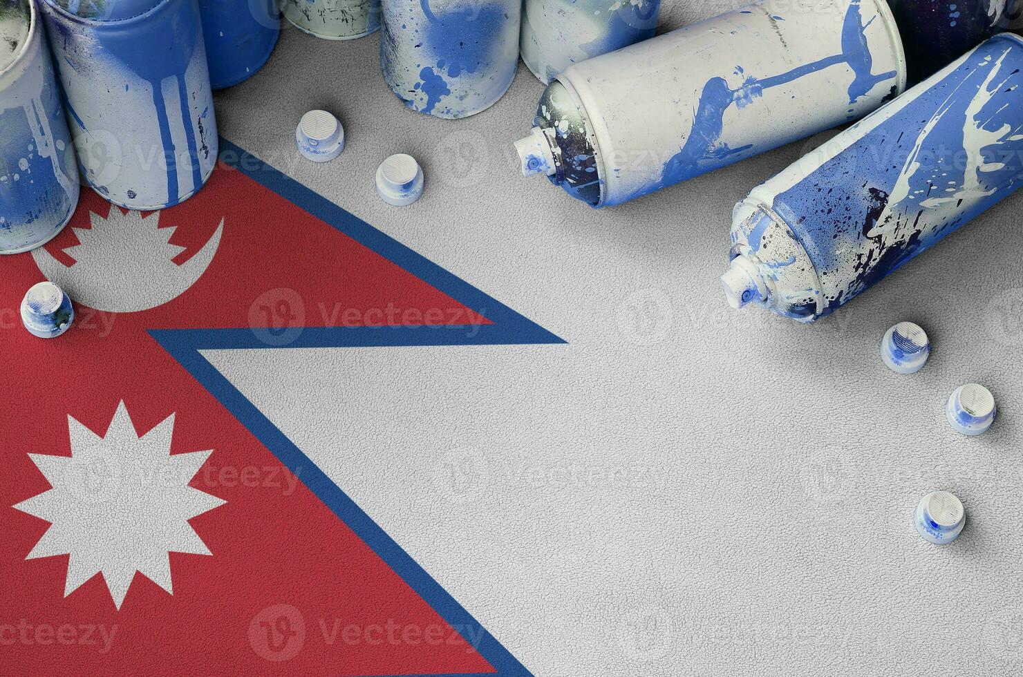 Nepal flag and few used aerosol spray cans for graffiti painting. Street art culture concept photo