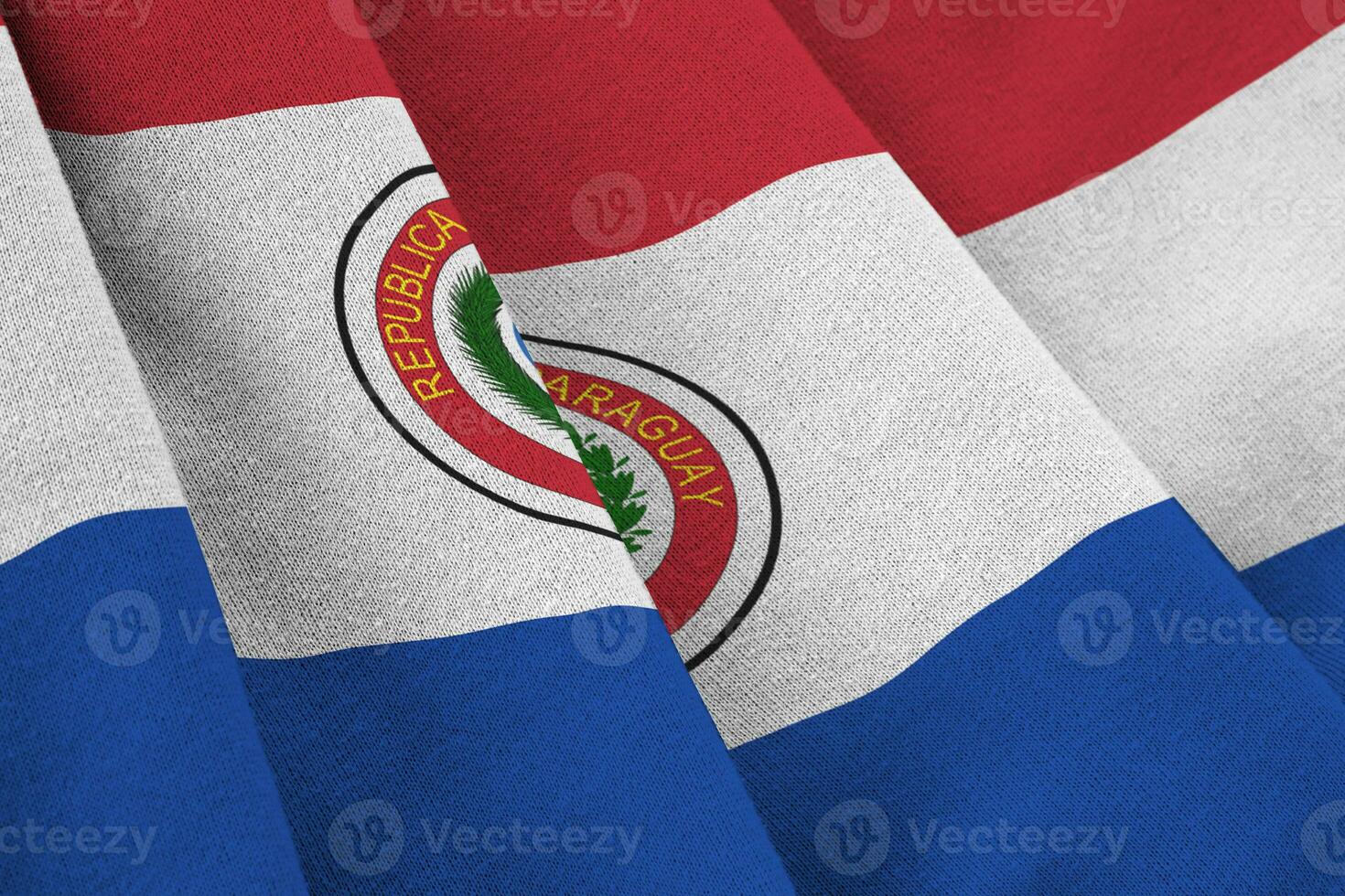 bandera paraguaya con grandes pliegues ondeando de cerca bajo la luz del estudio en el interior. los símbolos y colores oficiales en banner foto