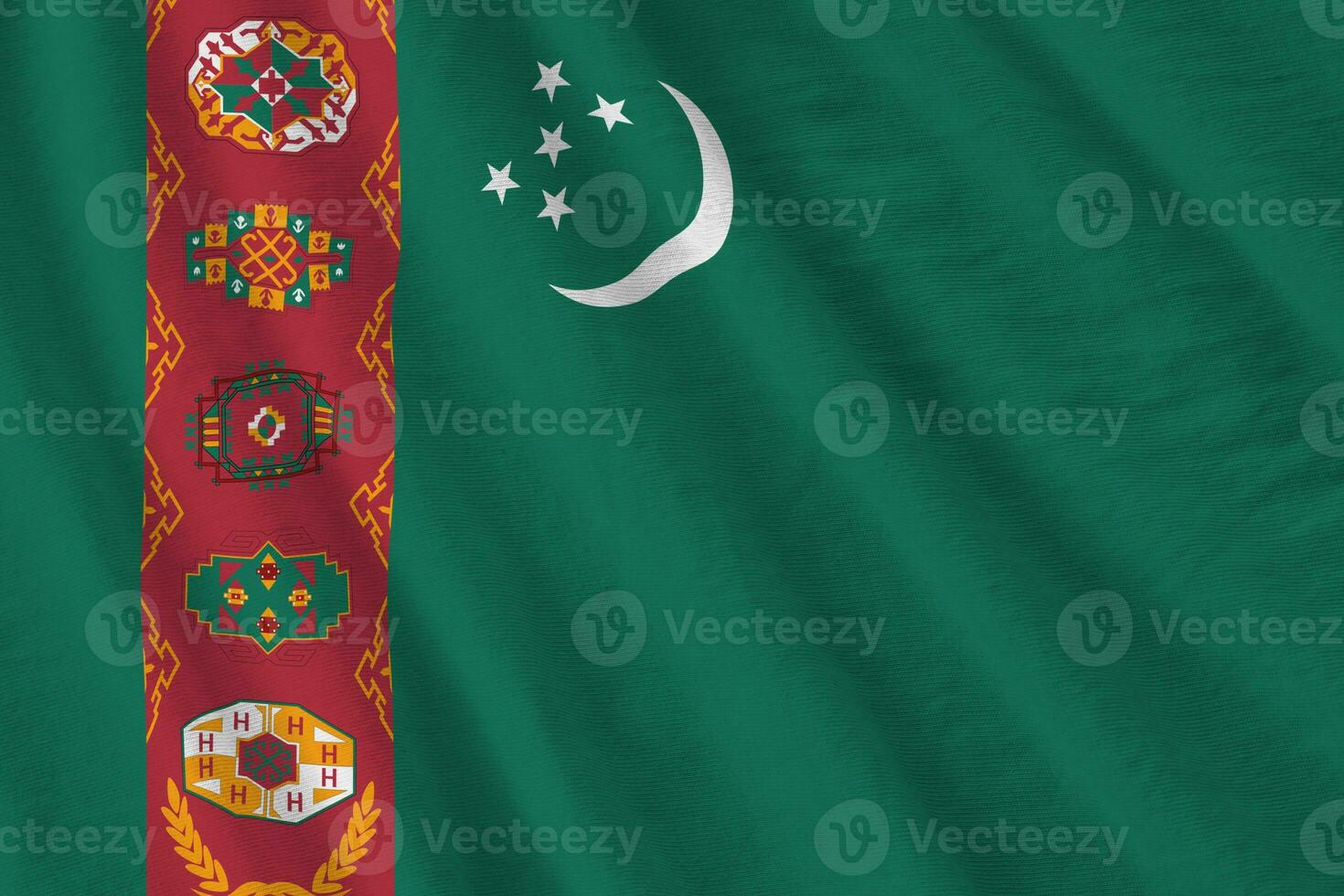 Turkmenistan flag with big folds waving close up under the studio light indoors. The official symbols and colors in banner photo