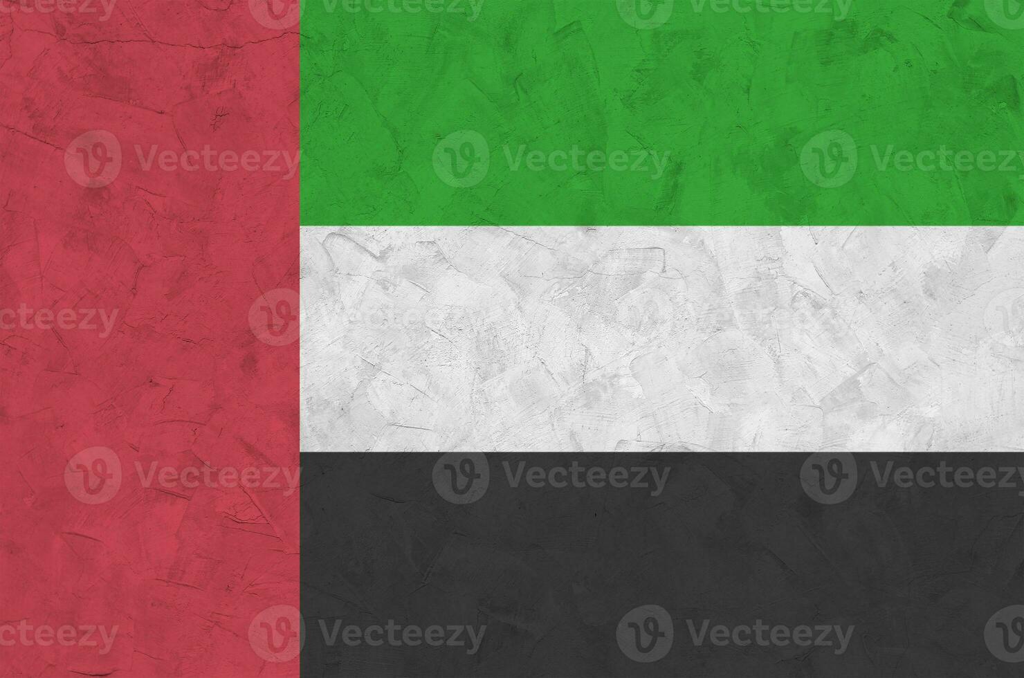 United Arab Emirates flag depicted in bright paint colors on old relief plastering wall. Textured banner on rough background photo