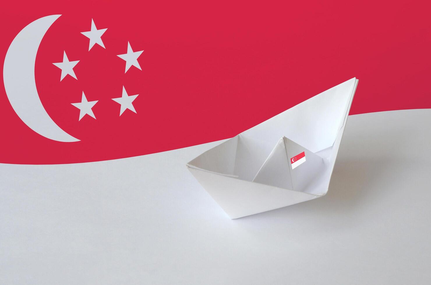 Singapore flag depicted on paper origami ship closeup. Handmade arts concept photo