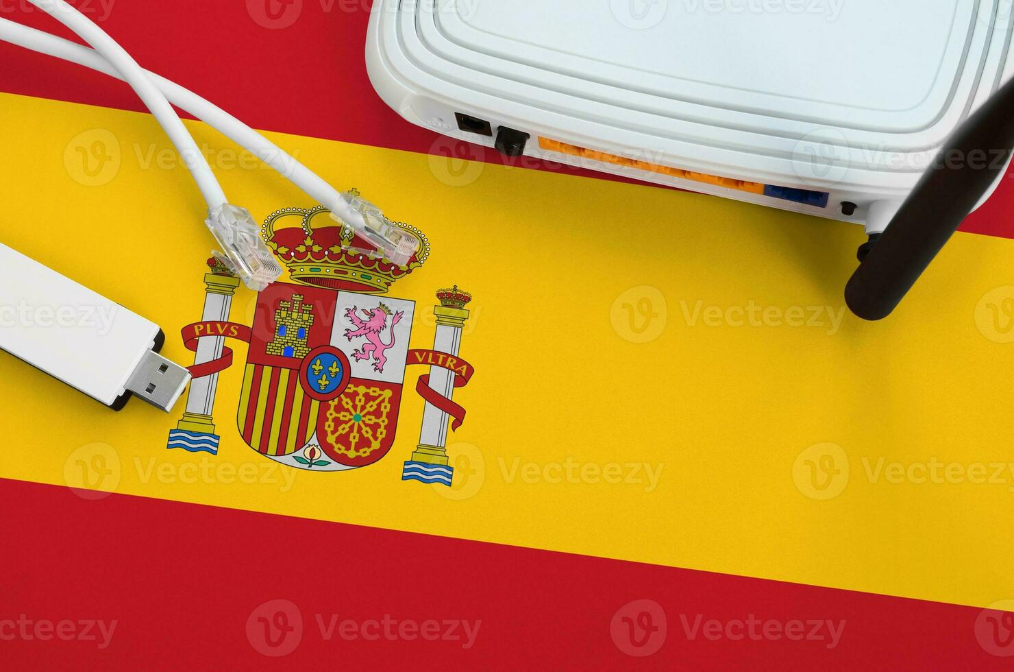 Spain flag depicted on table with internet rj45 cable, wireless usb wifi adapter and router. Internet connection concept photo